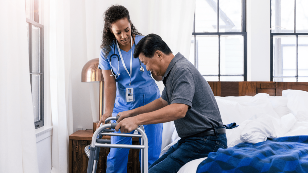 Physical therapist helping patient get out of bed using a walker