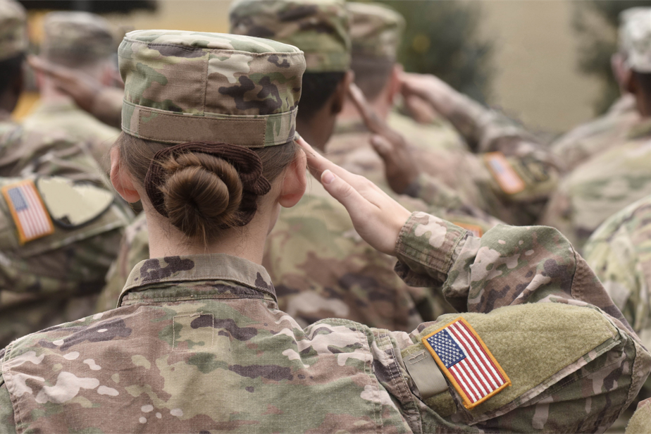 Group of soldiers saluting with focus on female soldier